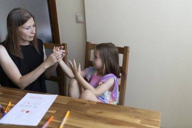 Öğretmenim evde özel bir ders sırasında genç bir öğrenciyle işaret dili kullanıyordu.