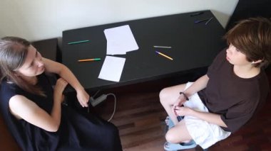 Psikolog terapi seansı sırasında genç hastasının sorunları hakkında konuşmalarını dinliyor.