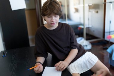 Not defterine konsantre olmuş öğrenci ödevlerini evde yapıyor.