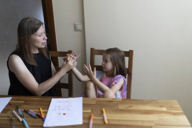 Öğretmenim evde özel bir ders sırasında genç bir öğrenciyle işaret dili kullanıyordu.