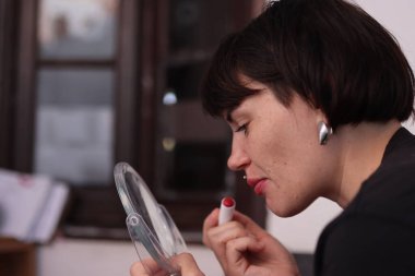 İş kadını kırmızı ruj sürüyor. İşe hazırlanıyor.