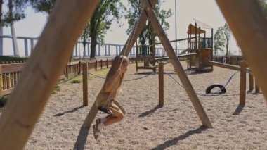 İki çocuk salıncakta sallanıyor.