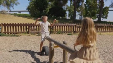 Mutlu çocuklar oyun parkında tahterevallide oynamaktan zevk alıyorlar.