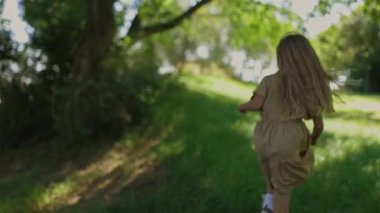 Mutlu bir aile güneşli bir günde parkta oynuyor.