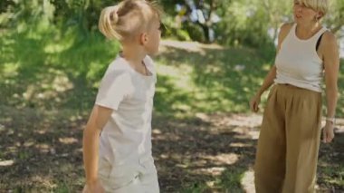 Anne ve oğlu güneşli bir parkta eğleniyor, birlikte oynuyor ve kendine vakit ayırıyor.