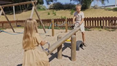 Mutlu çocuklar oyun parkında tahterevalliden zevk alıyorlar.