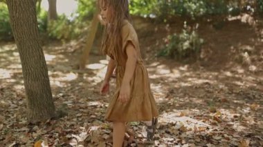 Güneşli bir günde parkta aile üyeleriyle oynayan bir kız.