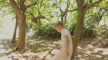 Güneşli bir günde parkta saklambaç oynayan iki çocuk.