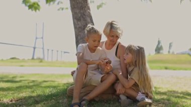Aile, köprünün yakınındaki bir parkta sohbetten zevk alıyor.