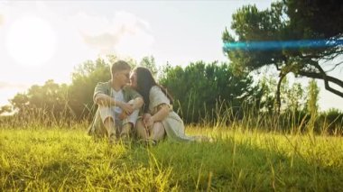 Genç çift doğada romantik bir anın tadını çıkarıyor, altın güneş ışığıyla yıkanmış.