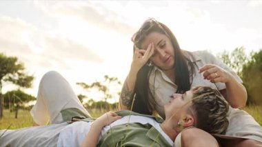 Romantik lezbiyen çift doğada rahatlatıcı bir anın tadını çıkarıyor, işaret diliyle sevgilerini ifade ediyorlar.