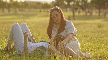 Çiftler doğada rahatlatıcı bir anın tadını çıkarıyorlar, nazik dokunuşlar ve samimi konuşmalarla bağlarını güçlendiriyorlar.