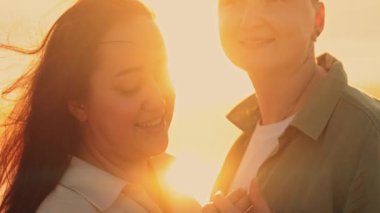 Güzel bir altın saat boyunca romantik bir anın tadını çıkaran arka plandaki çift.