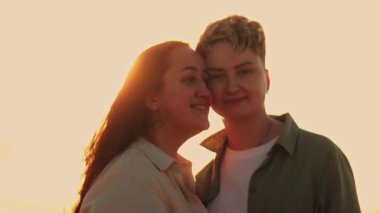 Günbatımında kucaklaşan lezbiyen bir çiftin romantik anları.