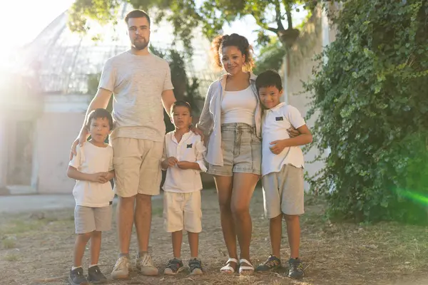 Mutlu beş kişilik aile parkta birlikte eğleniyor, birlik ve sevgiyi kucaklıyor.