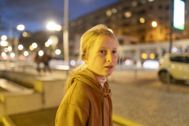 Gece ışıkları altında şehir sokaklarını keşfeden gençler