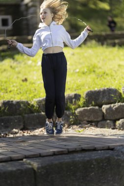 Parkta ip atlayan, açık hava aktivitelerinden ve sağlıklı yaşam tarzından hoşlanan bir kız.