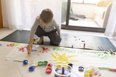 Anaokulunun rengarenk renk ve fırçalarla resim yapması yaratıcılığı ve hayal gücünü geliştiriyor.