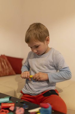 Mankenlik kilini manipüle etmeye odaklanan genç bir çocuk, evde yaratıcı ve eğitici bir aktiviteye girişiyor.