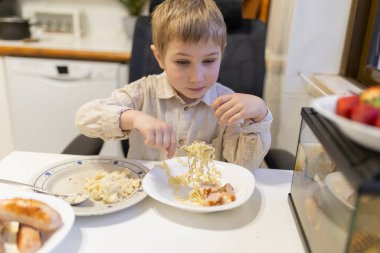 Anaokulunda erişte, sosis ve patates püresinin tadını çıkarıyordu.