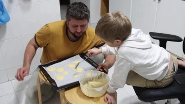 Baba, küçük oğluna kurabiye pişirmeyi öğretiyor. Yürek ısıtan bir aile anı yaratıyor.