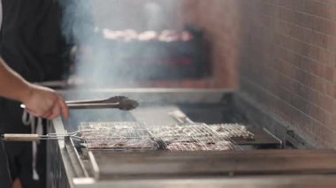 Profesyonel şef barbeküde et pişiriyor.