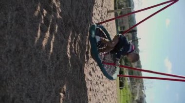 Küçük çocuk oyun parkında kuş yuvasının keyfini çıkarıyor.