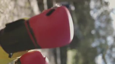 Çocuk boksör parkta yumruk pratiği yapıyor.