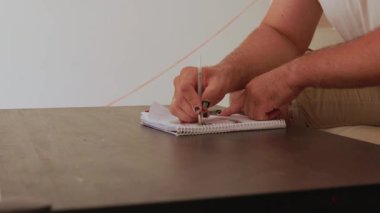 Not defteri üzerinde yazan adam