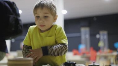 Genç bir çocuk, modern bir bilim müzesinde interaktif bir eğitim sergisiyle oynuyor.