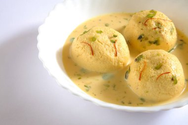 Hindistan tatlısı, kesar rasmalai garnitürü şam fıstığı ve safranla servis edilir.