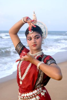 Dansçı geleneksel Odissi dansını Bengal Körfezi, Konarak, Orissa, Hindistan 'da yapıyor. 