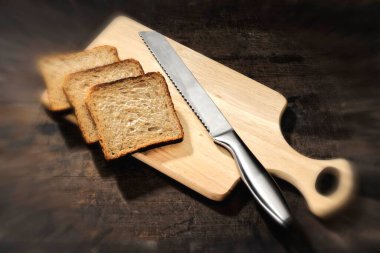 Mutfak eşyaları, ekmek bıçağı ve tahta kesme tahtası.