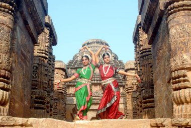 Dancers performing classical traditional odissi dance in front of Konarak Sun temple, Konarak, Orissa, India  clipart
