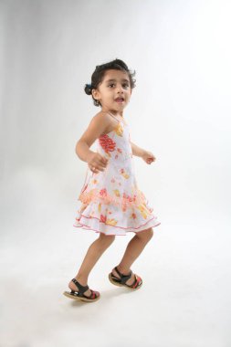 4 yıllık neşeli ruh hali dansçısı genç kız kendi etrafında dönüyor ve dönüyor.   