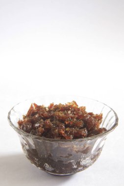 Gül yaprakları ve şekerden hazırlanan Gulkand beyaz arka planda kasede servis yapar. 