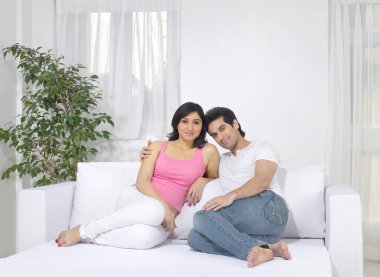 Yatakta oturan bir çift. Mutlu aile kavramı