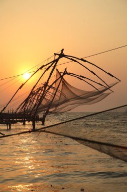 Akşamın geç saatlerinde Çin balık ağları ağ, güneş batarken Kochi Kalesi, Ernakulum Bölgesi, Kerala, Hindistan 