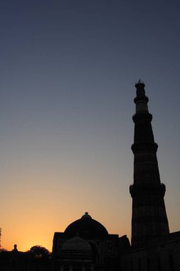 Kutub Minar 'da gün batımı 1311 kırmızı kumtaşı kulesinde inşa edildi, Indo _ Müslüman sanatı, Delhi sultanlığı, Delhi, Hindistan UNESCO Dünya Mirası Sitesi