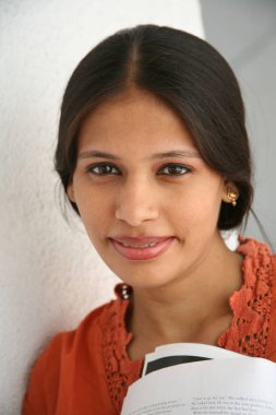 Güney Asyalı genç bayan kitap tutuyor.