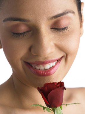 Güney Asyalı kadın gülümsüyor ve elinde kırmızı gül kokusu var MR 702