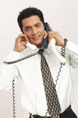 İş adamı üç telefon görüşmesi yapıyor. 