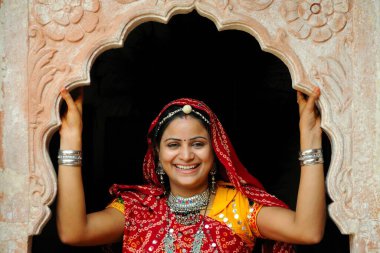 Rajasthani lady looking through jharoka , Rajasthan , India close up shot clipart