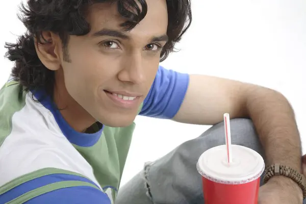 stock image Teenage boy holding glass of soft drink and smiling 
