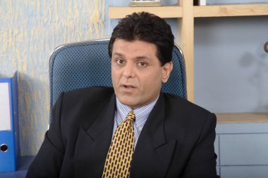 Yönetici kabinde oturmuş biriyle konuşuyor.