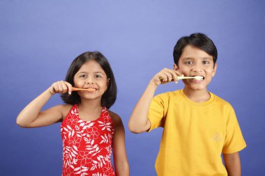 On ve sekiz yaşındaki çocuklar diş fırçalarıyla dişlerini fırçalıyorlar.