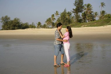 Güney Asyalı genç adam ve kadın birbirlerine yakın duruyorlar, Shiroda, Dist Sindhudurga, Maharashtra, Hindistan 