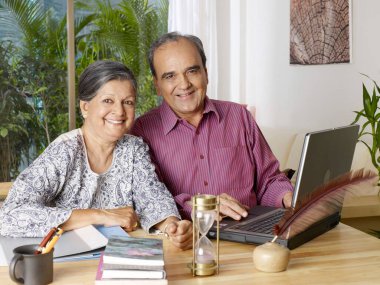 Yaşlı çift dizüstü bilgisayar kullanıyor 