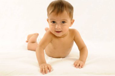 Bir yaşında, bebek bezi takmış, sinsi beyaz arka planda karnının üstünde yatıyor.