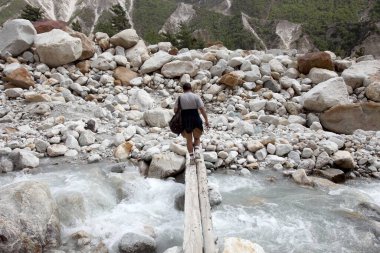 Trekker crossing river Bhagirathi Gangotri Uttarakhand India Asia clipart
